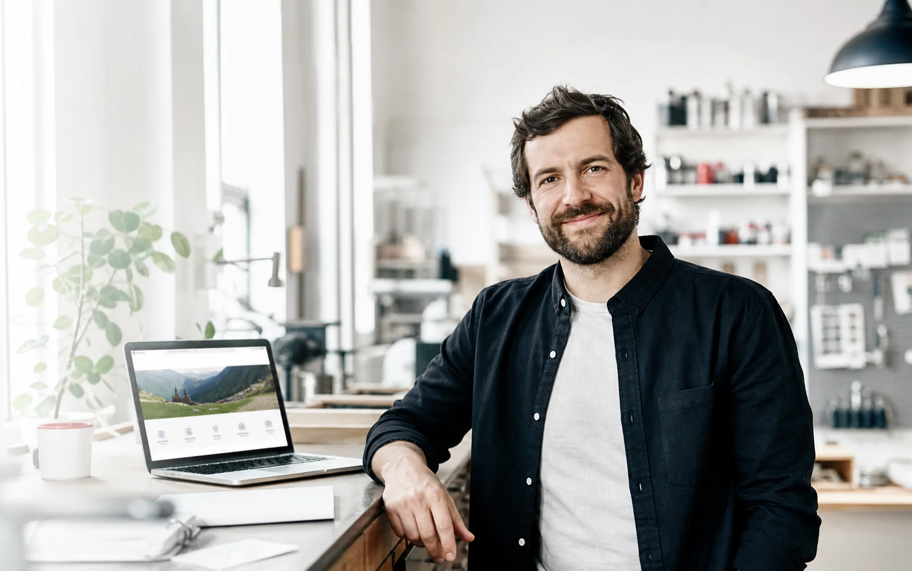 Owner of a Swiss SMB with a laptop in a bright local business